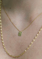 Sb Studio 14k yellow gold Dreamer pendant necklace layered with a delicate gold chain on a woman's neck.