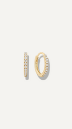 SB Studio Cecilia huggie hoop earrings in 14k yellow gold with a row of prong-set white topaz gemstones.