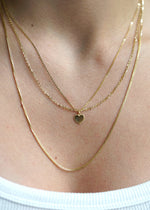 sb Studio 14k yellow gold sweetheart heart charm pendant on a delicate layered gold chain necklace.