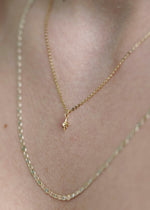 Sb Studio 14k yellow gold North Star diamond charm pendant on a delicate cable chain worn around the neck.