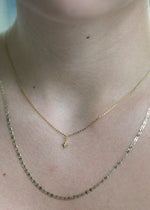 Sb Studio 14k yellow gold North Star charm pendant with a small diamond on a delicate cable chain worn on neck