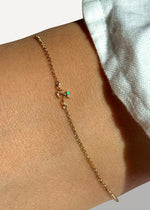 SB Studio gold zodiac charm bracelet with turquoise gemstone and anchor detail on a wrist.
