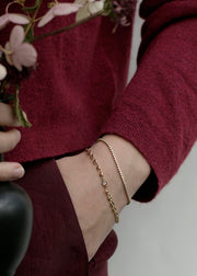 Person wearing solid gold bracelet and bezel diamond tennis bracelet from SB Studio in Alberta Canada