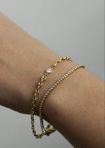Hand wearing a gold bracelet and bezel tenns bracelet from the SB studio formerly the Sparkle Bar