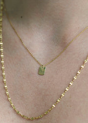 Sb Studio 14k yellow gold Dreamer pendant necklace layered with a delicate gold chain on a woman's neck.