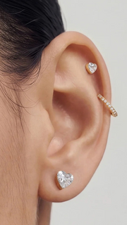 SB Studio Cecilia huggie hoop earrings in 14k gold with white topaz, worn in a layered ear stack.