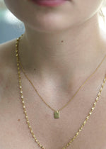 Sb Studio Dreamer Pendant in 14k yellow gold worn on a delicate chain around a woman's neck.
