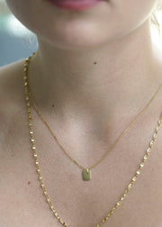 Sb Studio Dreamer Pendant in 14k yellow gold worn on a delicate chain around a woman's neck.