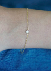 Sb Studio Fleur charm bracelet in 14k yellow gold featuring a delicate flower with white topaz gemstones.