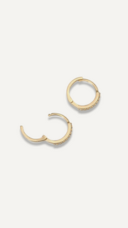 SB Studio Cecilia huggie hoop earrings in 14k yellow gold with prong-set white topaz stones.