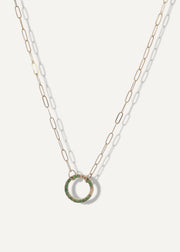 SB studio solid 14k gold paperclip chain necklace featuring a circular charm holder embellished with small green gemstones.