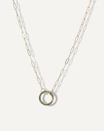 SB studio solid 14k gold paperclip chain necklace featuring a circular charm holder embellished with small green gemstones.