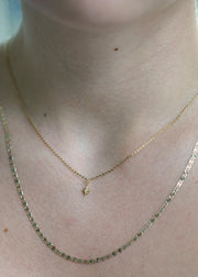 Sb Studio 14k yellow gold North Star charm pendant with a small diamond on a delicate cable chain worn on neck