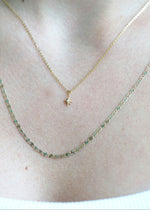 Sb Studio 14k yellow gold North Star charm pendant with a small diamond on a delicate cable chain worn on neck