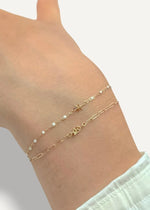 sb studio gold zodiac charm bracelet with Pisces symbol and small pearls on a wrist.