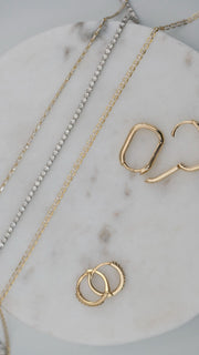 diamond tennis bracelet and necklaces paired with solid 14k gold hoop earrings