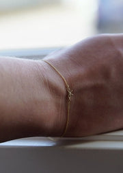 solid gold charm bracelet with bow charm from SB Studio in edmonton alberta