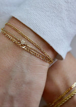 Close-up of a wrist wearing multiple solid gold bracelets from SB Studio in Edmonton Alberta