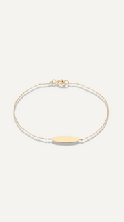 The Sparkle Bar 14k yellow gold signet charm bracelet with a delicate beaded chain and engravable oval charm.