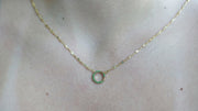 The Sparkle Bar 14k yellow gold circular charm holder necklace featuring shimmering green gemstones on a delicate chain