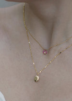 The Sparkle Bar 14k gold Honeybee Locket pendant worn on a delicate chain layered with a pink gemstone necklace.