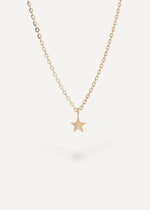 The Sparkle Bar Make A Wish gold star charm necklace on a delicate chain against a cream background.