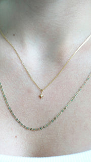The Sparkle Bar Penelope necklace featuring a delicate tri-colour gold Valentino chain worn layered on a neck.