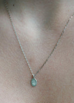 The Sparkle Bar sterling silver oval Poet Pendant necklace featuring a small engraved paw print on a delicate chain.
