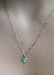 The Sparkle Bar sterling silver oval Poet Pendant necklace featuring a small engraved paw print on a delicate chain.